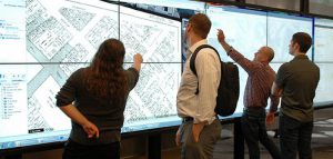 photo of people using a data visualization wall