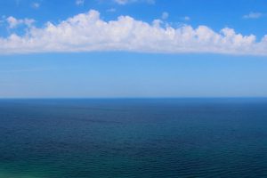 Photo of blue sea, blue sky, and white clouds
