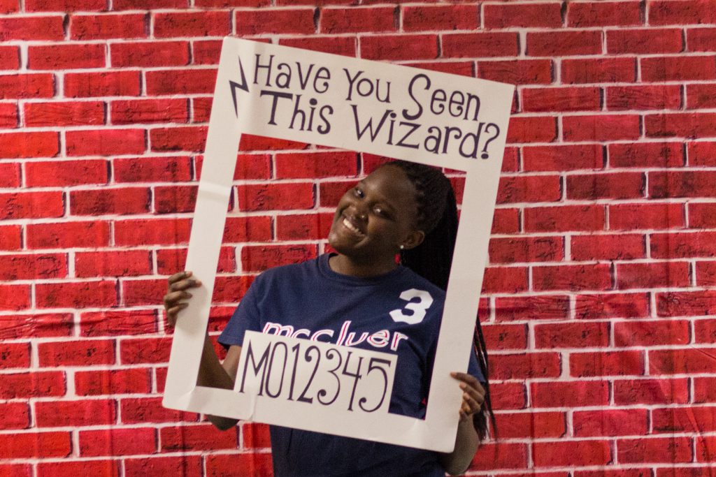 Student posing with a frame that says Have you seen this wizard?