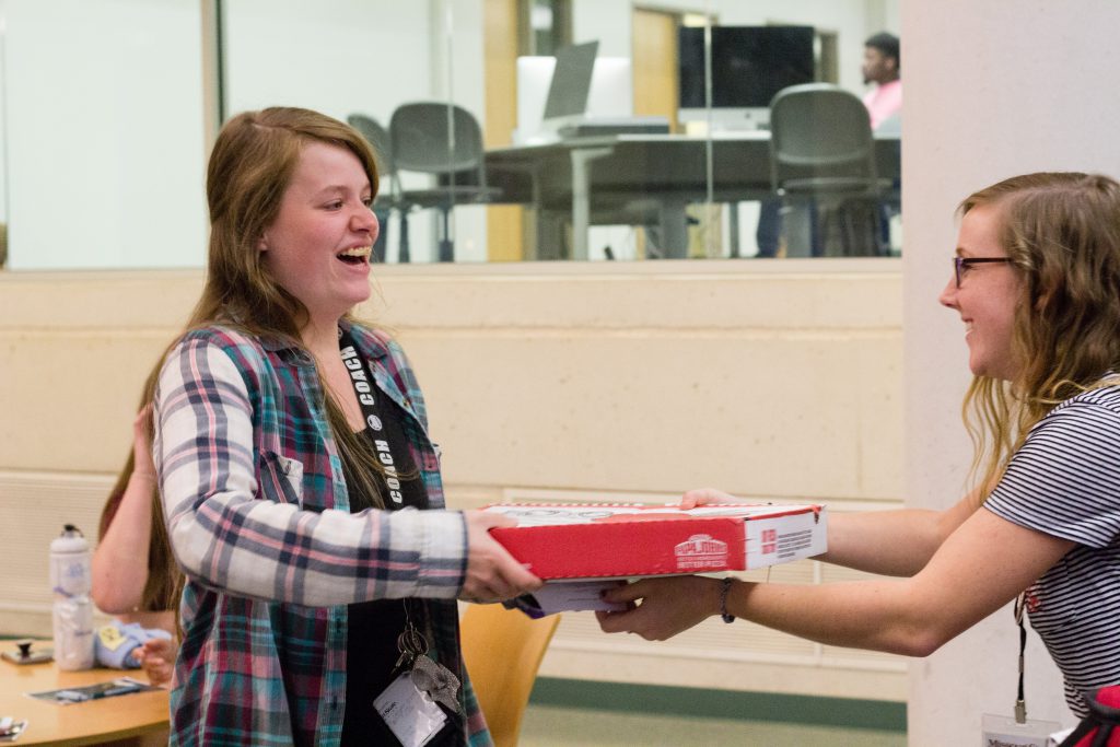 Student receiving a pizza as a prize