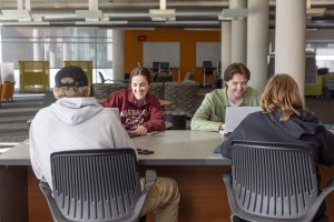 Group of four students seated at table in Meyer Library.