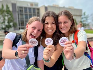 3 MSU students holding up the buttons they made