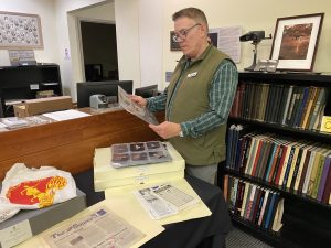 A man examines items in the OLGA Collection