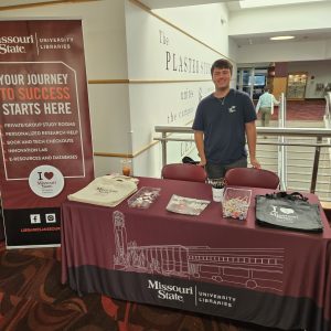 Ethan Danner stands at the Libraries' table at Showcase 2023