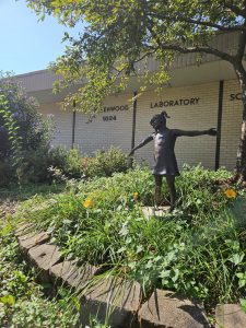 Metal sculpture of a school girl outside Greenwood Lab School