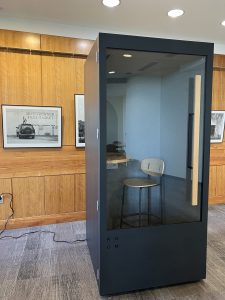 This is an image of the phone booth in Meyer Library on the third floor. It is a black box with a window on the front and a wooden handle on the righthand side.