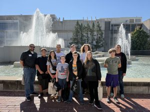 Picture of a group of students and teachers from Buffalo Prairie Middle School standing in front of the fountain outside of the Duane G. Meyer Library