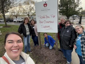 Employees of Meyer Library stand with a sign for Ozarks Food Harvest