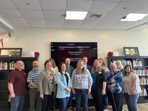 A gathering of library professionals and Missouri State University administrators, including president Biff Williams and interim provost Tammy Jahnke, stand for a picture with Jessica Bennett and Raegan Wiechert