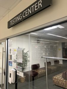 Meyer Library testing center. There is a sign that says "Testing Center" and a glass door and glass windows.