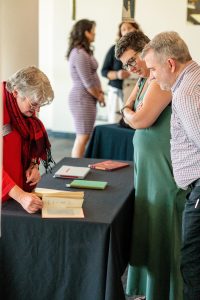 Anne Baker, head of special collections, looks at manuscripts with attendees