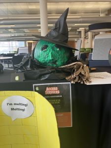 picture of the pumpkin painted to look like the Wicked Witch of the West from The Wizard of Oz. The pumpkin is green with a witches hat.