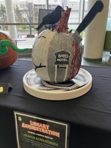 Pumpkin with a knife from the movie Psycho protruding from the gourd as well as a bird perched on the pumpkin.