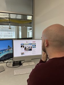 Man sits at computer and reads the Springfield Daily Citizen.